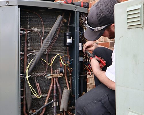 service-repair-being-done-on-a-heat-pump-hvac-syst-CUZ5KG7-min